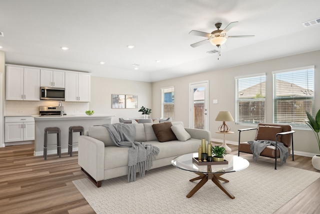 living room with light wood-type flooring and ceiling fan