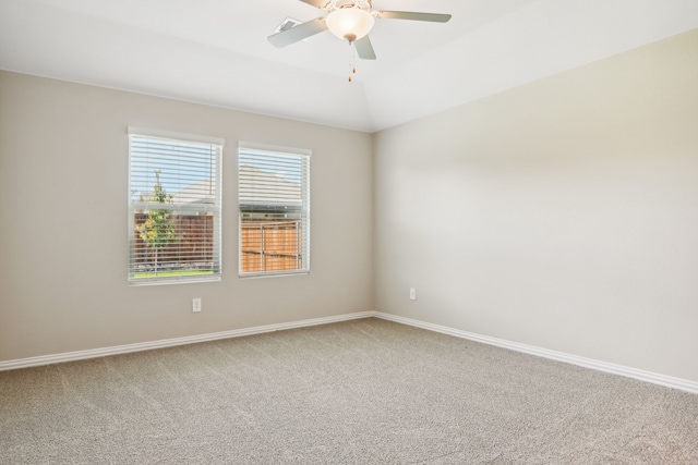 unfurnished room with carpet floors, lofted ceiling, visible vents, ceiling fan, and baseboards