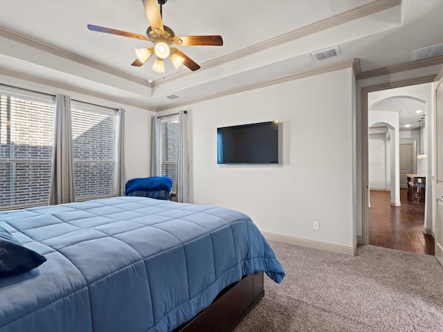 bedroom with ceiling fan, ornamental molding, and a tray ceiling