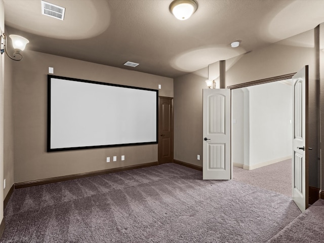 cinema featuring a textured ceiling and dark colored carpet