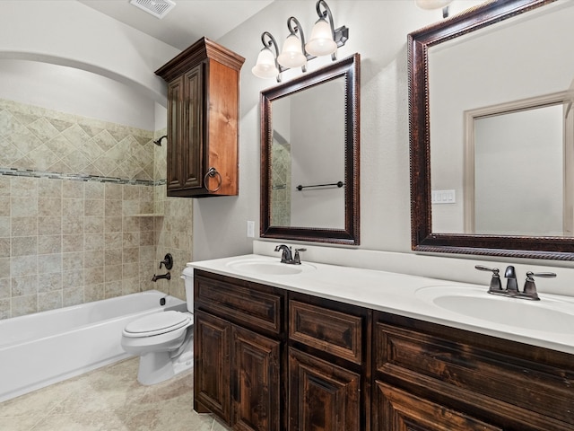 full bathroom with toilet, tiled shower / bath, vanity, and tile patterned floors