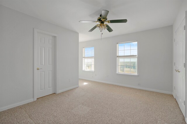 carpeted empty room featuring ceiling fan