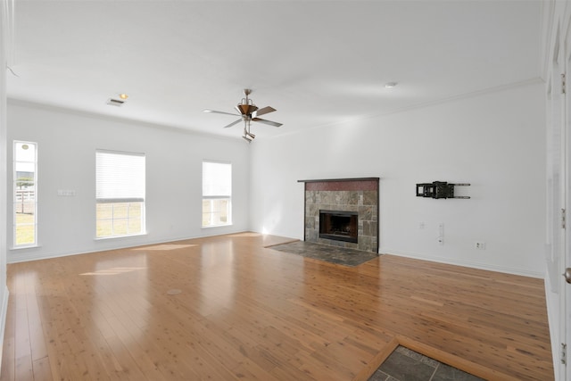 unfurnished living room featuring ornamental molding, hardwood / wood-style floors, a fireplace, and ceiling fan