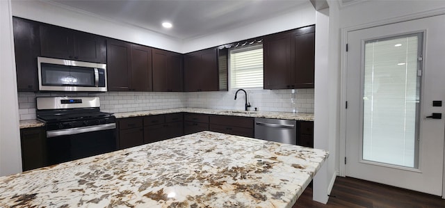 kitchen featuring dark wood-type flooring, stainless steel appliances, backsplash, dark brown cabinets, and sink