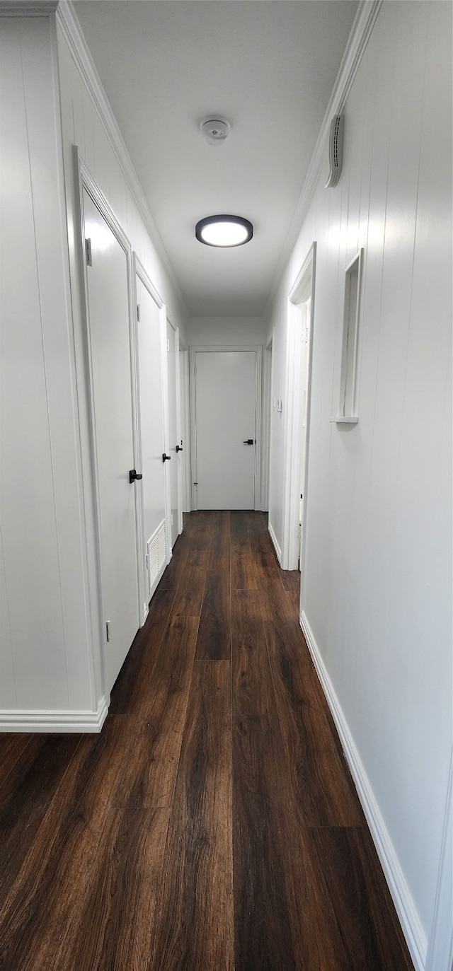 hallway with crown molding and dark hardwood / wood-style floors