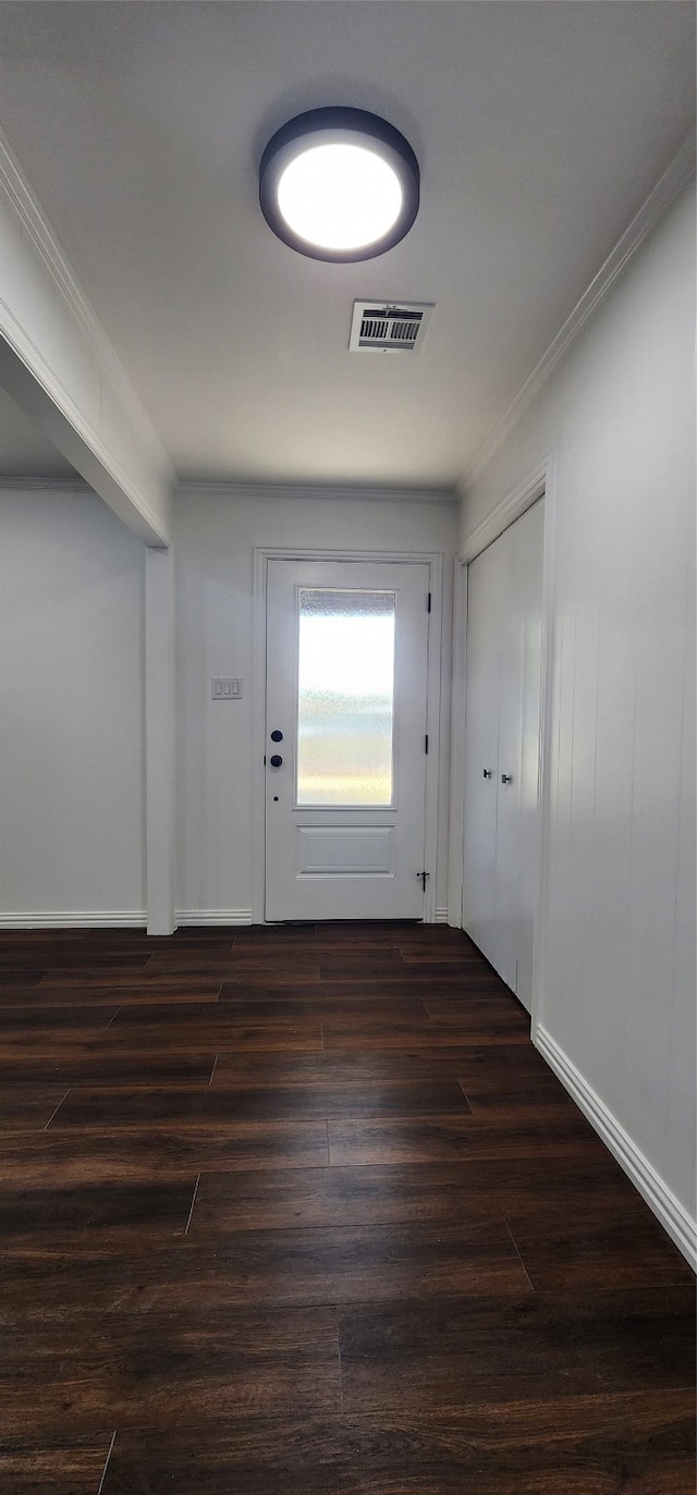 foyer with ornamental molding and dark hardwood / wood-style floors