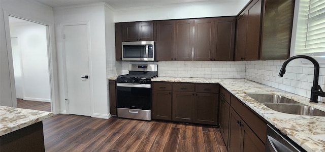 kitchen with ornamental molding, dark wood-type flooring, sink, dark brown cabinetry, and stainless steel appliances