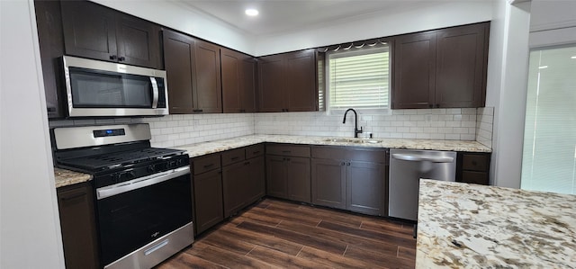 kitchen featuring decorative backsplash, dark brown cabinets, dark hardwood / wood-style floors, sink, and stainless steel appliances