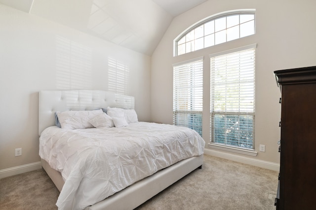 carpeted bedroom with lofted ceiling