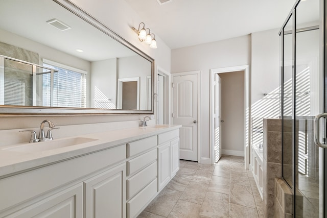 bathroom with vanity and shower with separate bathtub