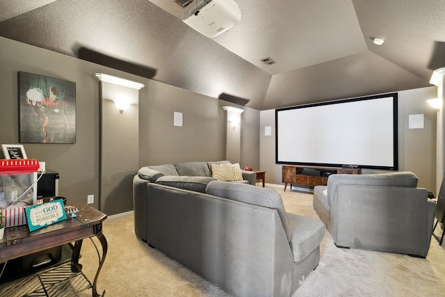 carpeted home theater with a textured ceiling, decorative columns, and vaulted ceiling