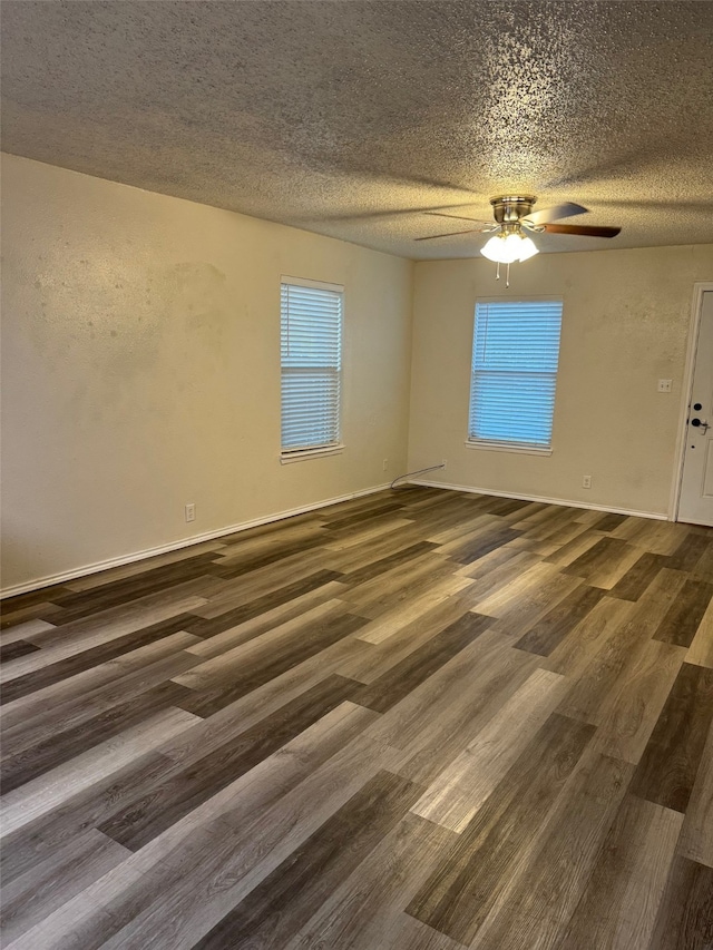 empty room with ceiling fan, a textured ceiling, and dark hardwood / wood-style flooring