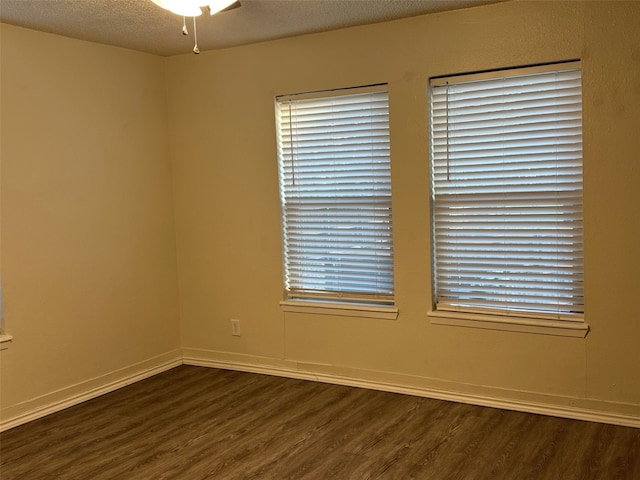 empty room with dark wood-type flooring, ceiling fan, and a textured ceiling