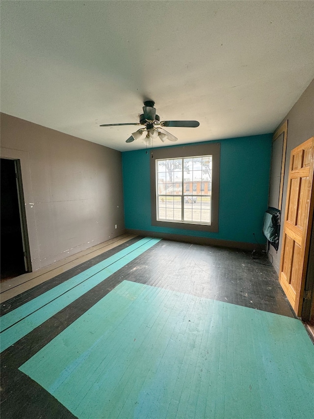 unfurnished living room featuring dark hardwood / wood-style floors and ceiling fan