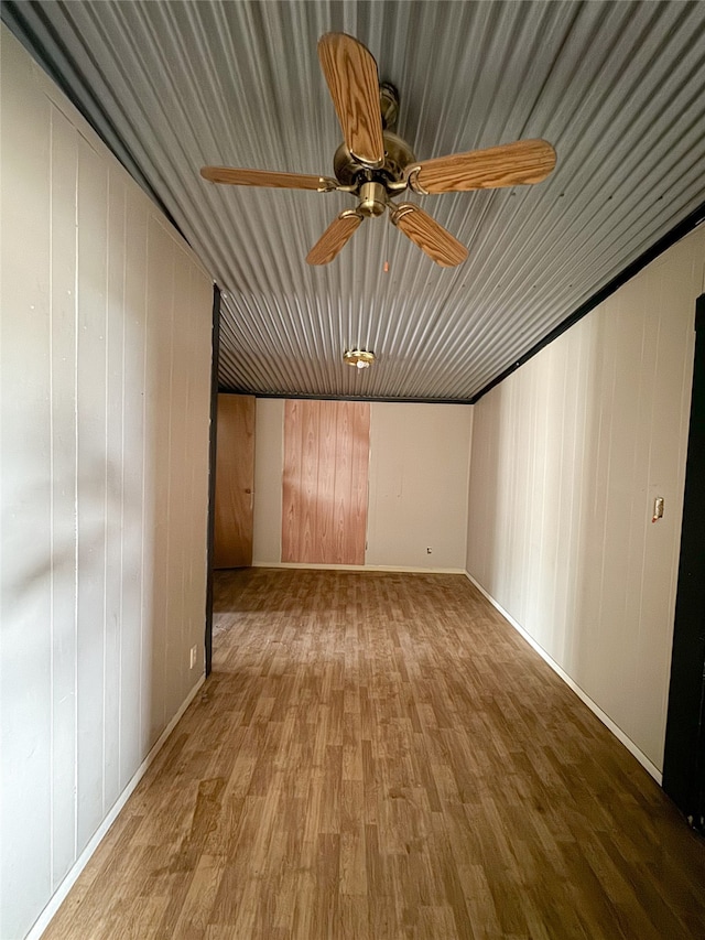 spare room with wooden walls, hardwood / wood-style flooring, and ceiling fan