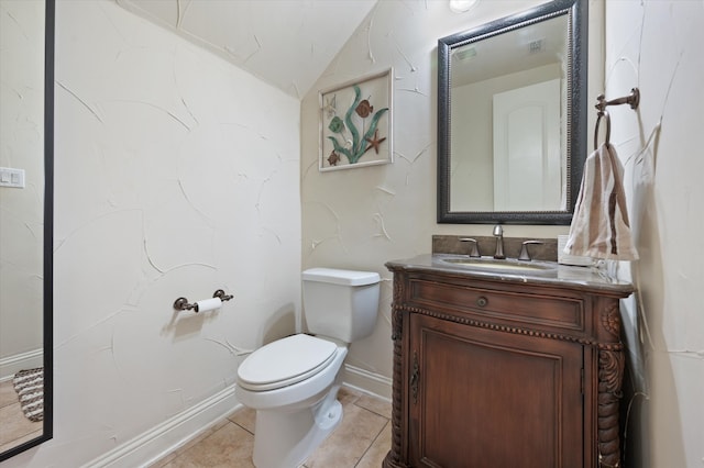 bathroom with toilet, vanity, tile patterned floors, and vaulted ceiling