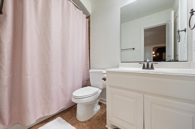 bathroom featuring toilet, curtained shower, vanity, and tile patterned floors