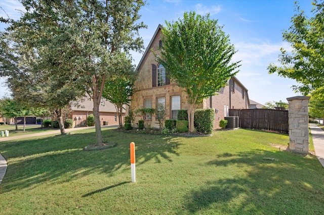 view of front of home featuring a front yard and cooling unit