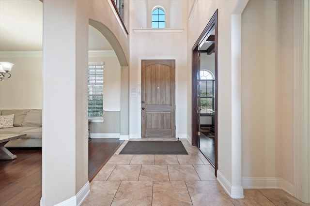 entryway featuring ornamental molding, light hardwood / wood-style flooring, and a wealth of natural light