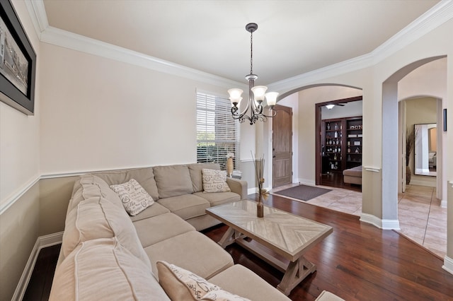 living room featuring hardwood / wood-style flooring, ornamental molding, and a chandelier