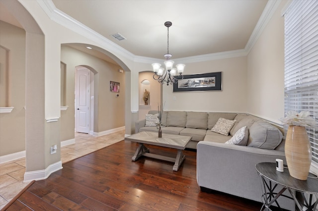 living room featuring crown molding, dark hardwood / wood-style floors, and a chandelier