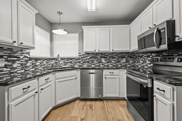 kitchen with white cabinetry, appliances with stainless steel finishes, and light hardwood / wood-style flooring