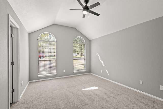 carpeted empty room featuring ceiling fan and lofted ceiling