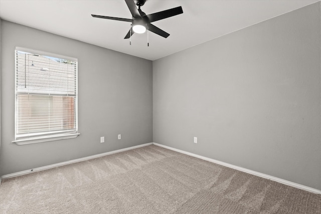 carpeted spare room featuring ceiling fan