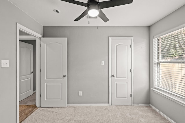 unfurnished bedroom with a closet, ceiling fan, and light colored carpet