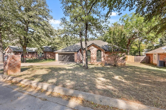 view of front of home featuring central air condition unit, a front yard, and a garage