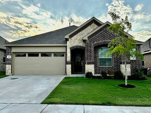 view of front of property with a garage and a lawn