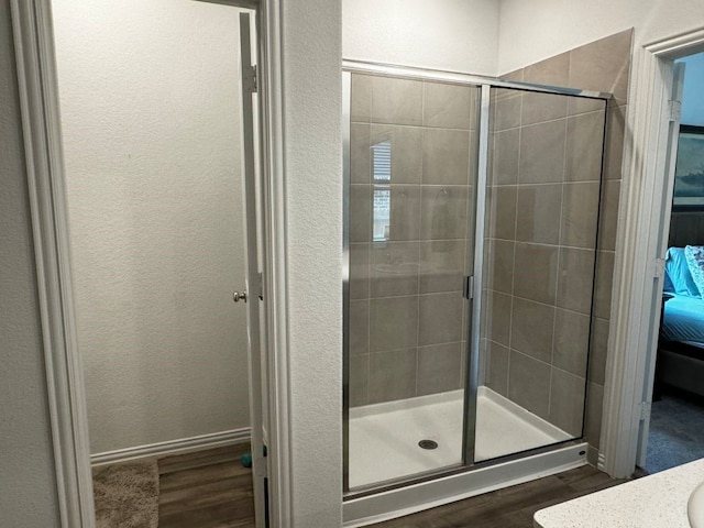 bathroom featuring an enclosed shower and hardwood / wood-style flooring