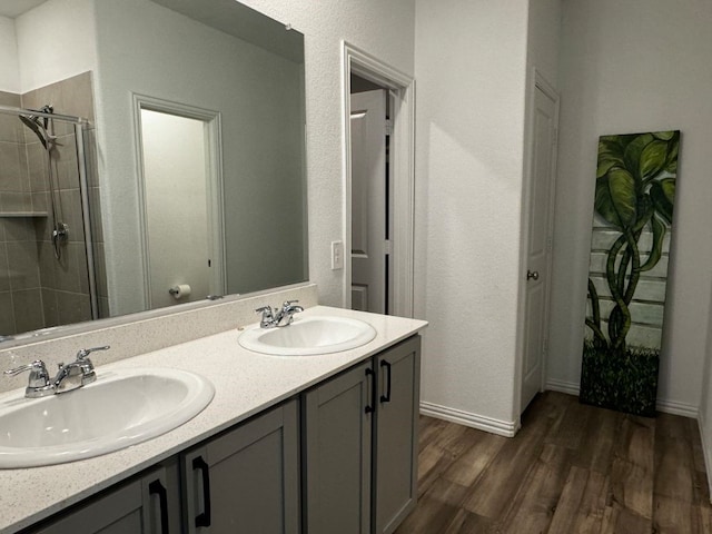 bathroom with a shower with door, vanity, and hardwood / wood-style flooring