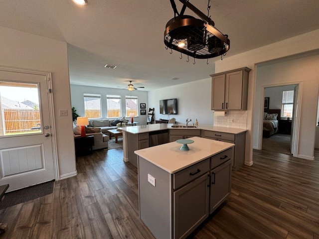 kitchen featuring dark wood-type flooring, kitchen peninsula, and gray cabinetry