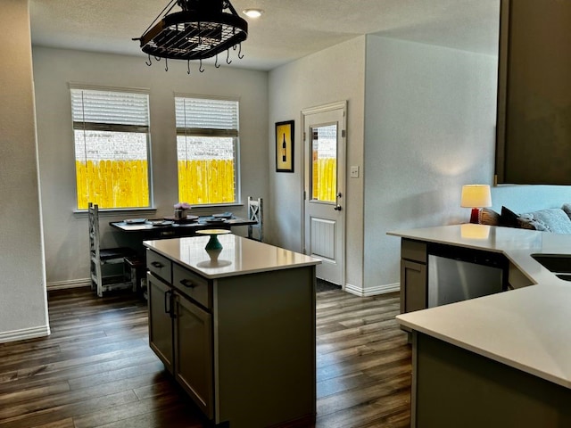 kitchen featuring stainless steel dishwasher, a kitchen island, dark hardwood / wood-style floors, and a textured ceiling