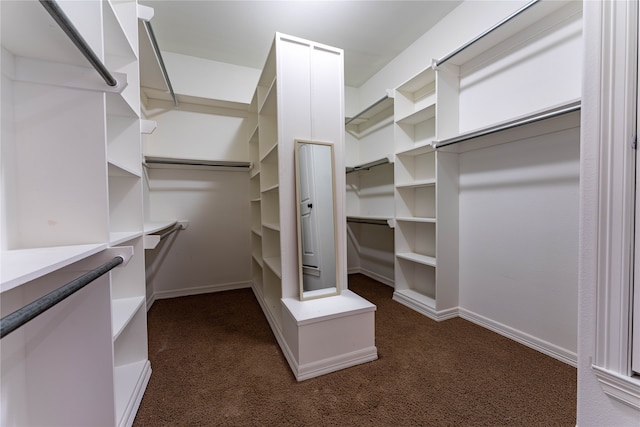 walk in closet featuring dark carpet