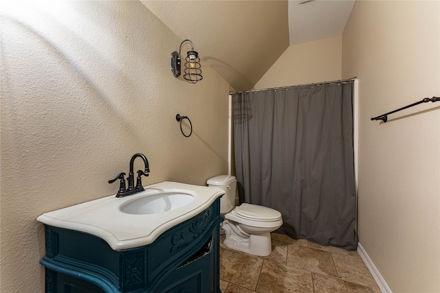 bathroom with vanity, toilet, and lofted ceiling