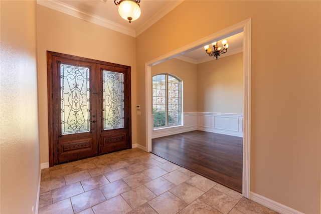 entryway featuring french doors, crown molding, a notable chandelier, and light wood-type flooring