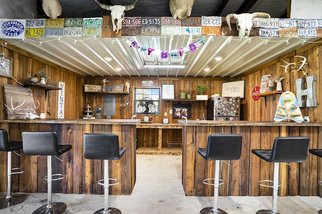 bar featuring concrete floors and wood walls