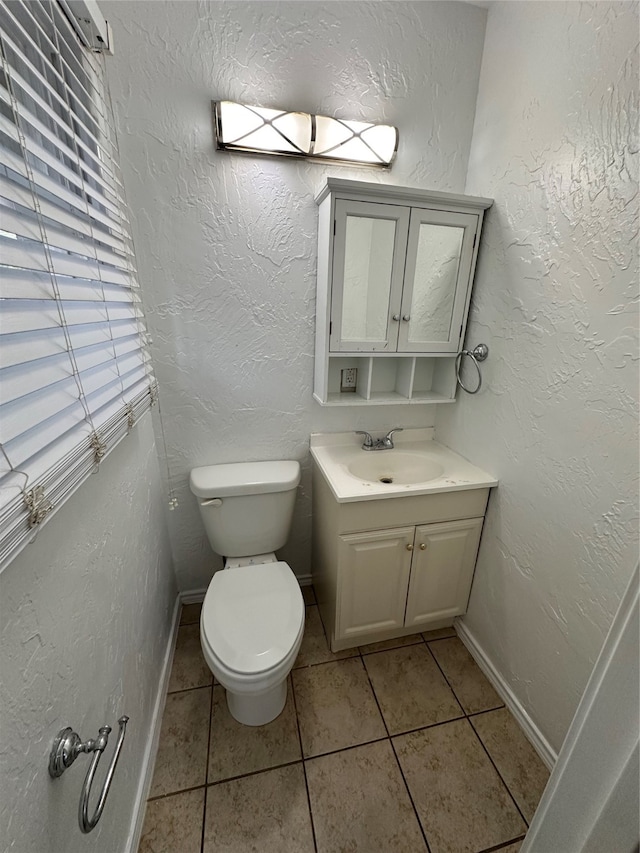 bathroom featuring vanity, tile patterned flooring, and toilet