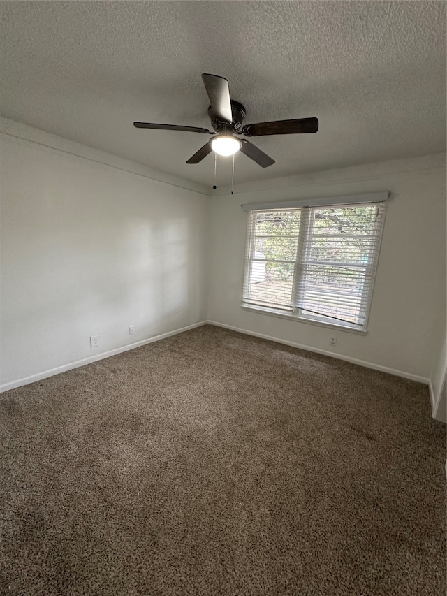 empty room featuring ceiling fan, dark carpet, and a textured ceiling