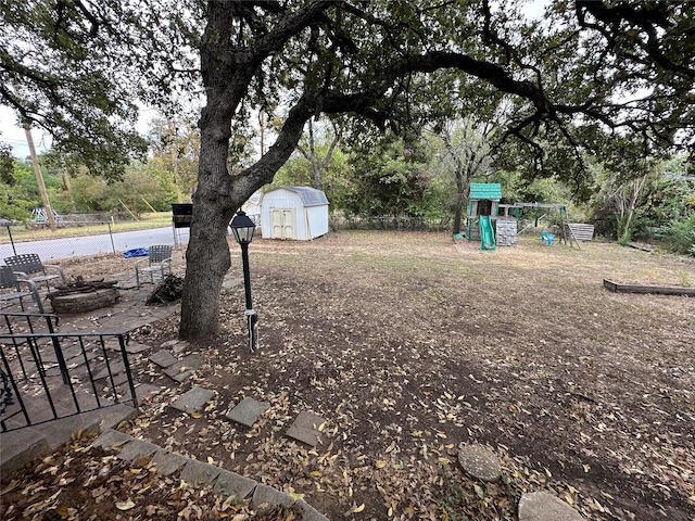 view of yard with a patio, a storage unit, a playground, and a fire pit