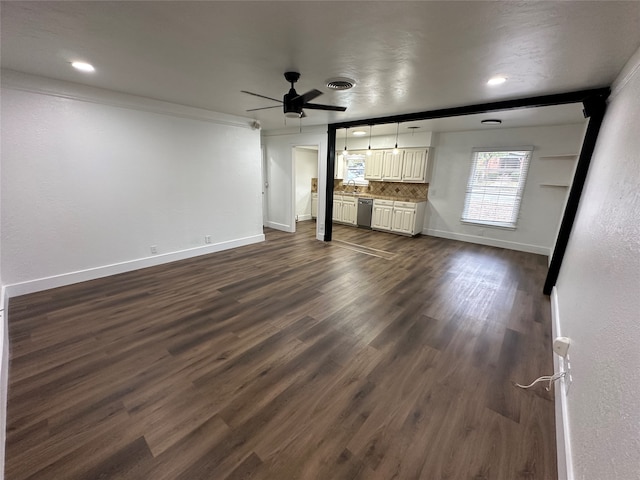 unfurnished living room featuring dark hardwood / wood-style flooring, sink, crown molding, and ceiling fan