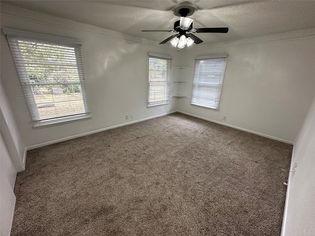 carpeted empty room featuring ceiling fan and a textured ceiling