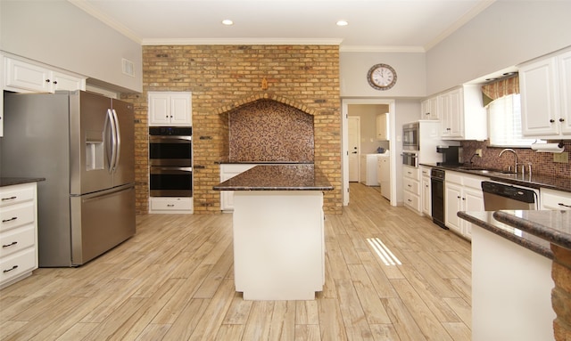 kitchen with appliances with stainless steel finishes, light hardwood / wood-style flooring, white cabinetry, and a kitchen island