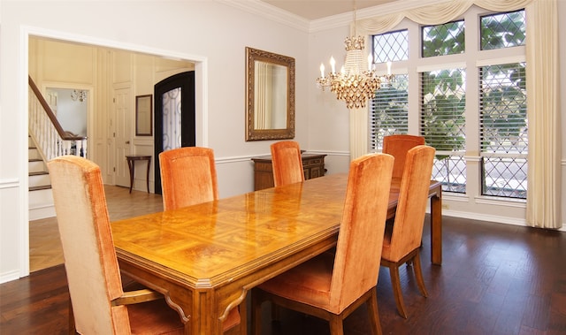 dining room featuring dark wood-type flooring, ornamental molding, and a chandelier