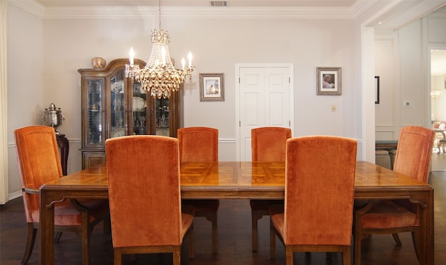 dining room featuring crown molding, dark hardwood / wood-style flooring, and a chandelier