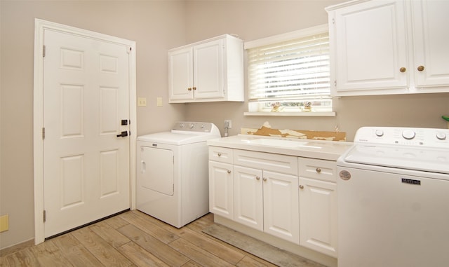 laundry room with separate washer and dryer, cabinets, and light wood-type flooring