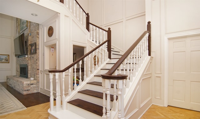 stairs featuring parquet flooring and a fireplace