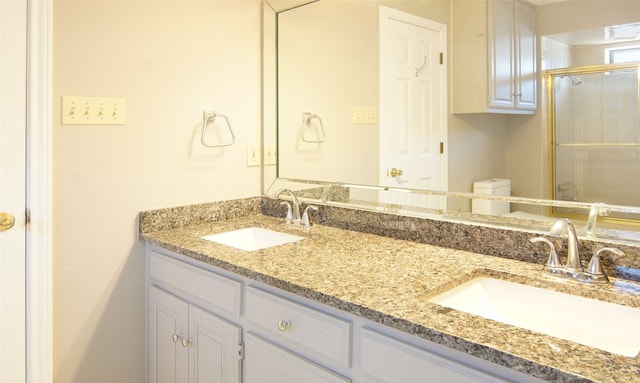 bathroom featuring vanity, toilet, and a shower with shower door